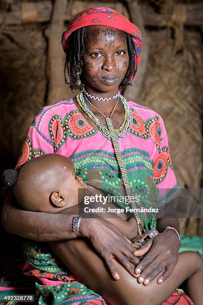 Portrait of a Mbororo woman with her child inside a hut.