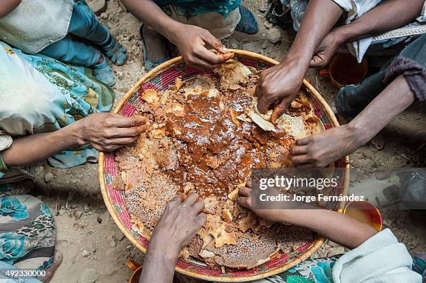 Hands of people sharing a traditional dish during a wedding celebration.