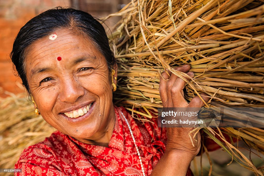 Nepali woman carrying rice straw in Bhaktapur, Nepal