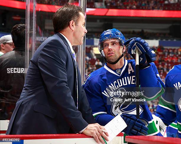 Assistant coach Doug Lidster of the Vancouver Canucks talks to Dan Hamhuis of the Vancouver Canucks during their NHL game against the Calgary Flames...