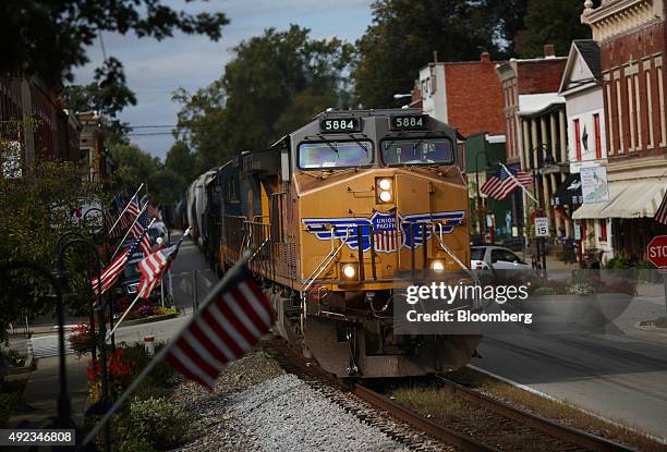 Northbound CSX Corp. Mixed freight train with a Union Pacific Railroad locomotive on point travels down Main Street in La Grange, Kentucky, U.S., on...