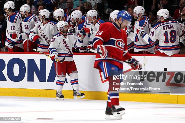 Martin St. Louis of the New York Rangers celebrates with his teammates on the bench after scoring a goal against Dustin Tokarski of the Montreal...