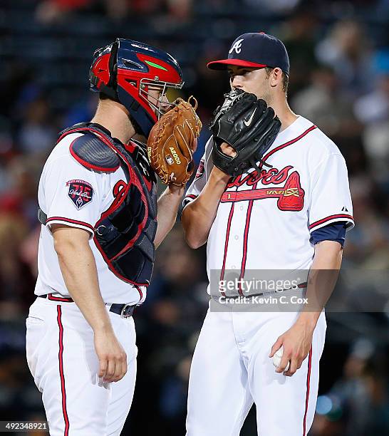 Evan Gattis converses with Mike Minor of the Atlanta Braves in the sixth inning against the Milwaukee Brewers at Turner Field on May 19, 2014 in...
