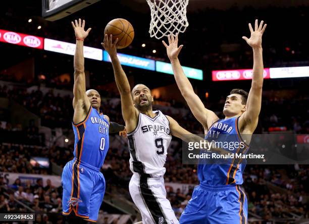 Tony Parker of the San Antonio Spurs goes up for a shot between Russell Westbrook and Steven Adams of the Oklahoma City Thunder in the first half in...