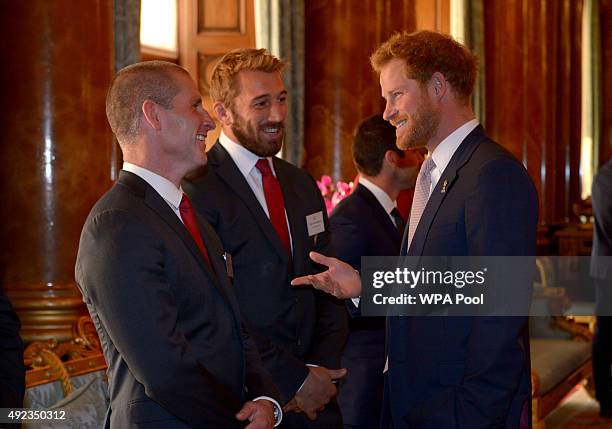 Prince Harry speaks with England Rugby Union head coach Stuart Lancaster and England captain Chris Robshaw during a reception to mark the Rugby World...