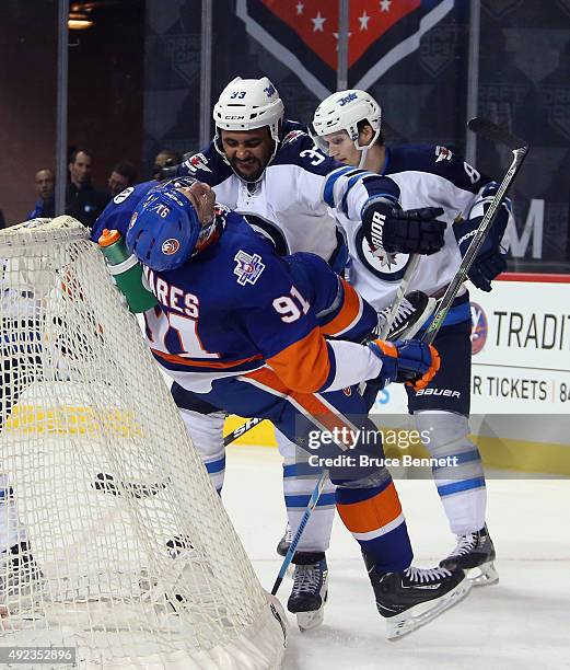 Dustin Byfuglien of the Winnipeg Jets takes a two minute penalty for roughing John Tavares of the New York Islanders during the second period at the...