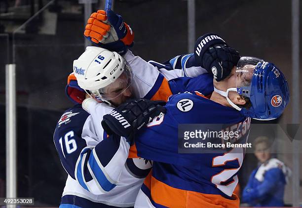 Andrew Ladd of the Winnipeg Jets and Brock Nelson of the New York Islanders battle during the second period at the Barclays Center on October 12,...