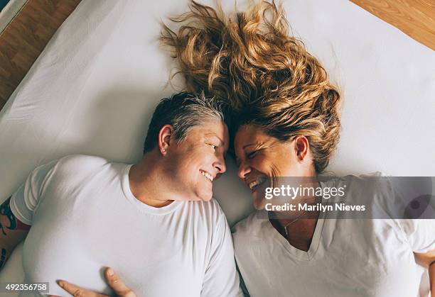 happy female couple laughing - lesbian bed stock pictures, royalty-free photos & images
