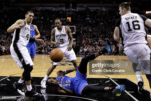 Kevin Durant of the Oklahoma City Thunder on the floor as the ball flies over his head against Danny Green and Kawhi Leonard of the San Antonio Spurs...