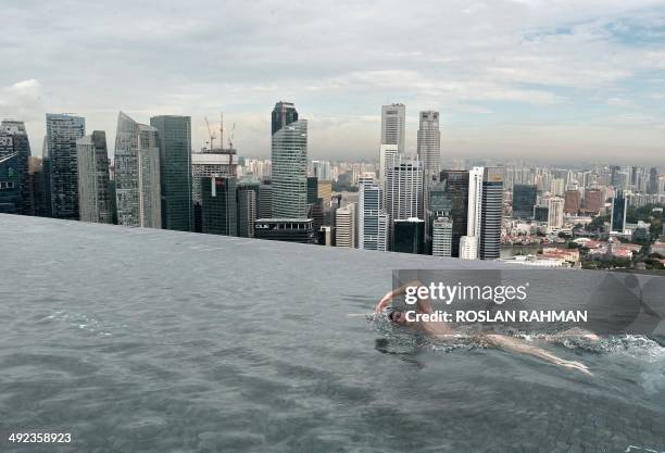 World Champion Christian Sprenger of Australia swims during a swimming clinic session for children with special needs on the rooftop pool of the...