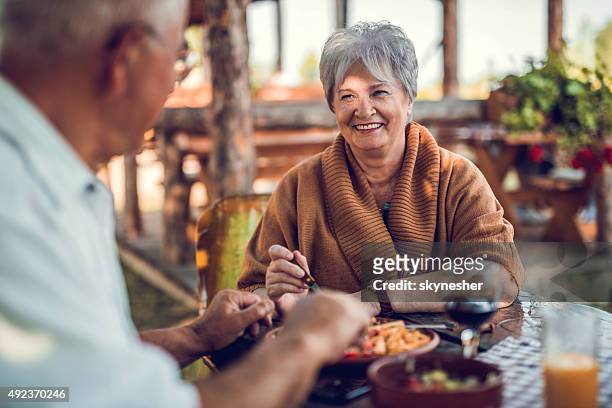 senior woman talking to her husband during a lunch. - old couple restaurant stockfoto's en -beelden