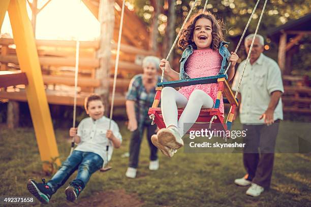 schwingen ihre großeltern enkel. - playground stock-fotos und bilder