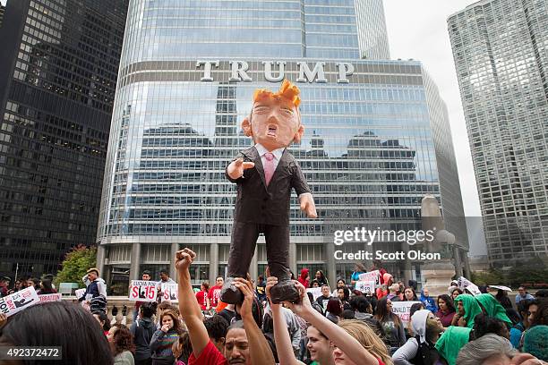 Demonstrators hold up a piñata of Republican Presidential candidate Donald Trump during a protest outside Trump Tower on October 12, 2015 in Chicago,...