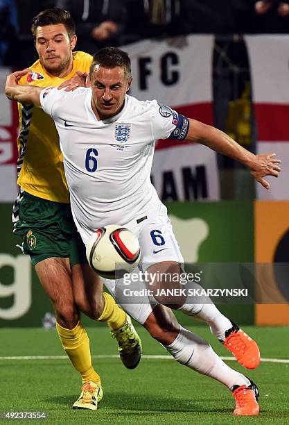 England's captain Phil Jagielka and Lithuania's forward Lukas Spalvis vie for a ball during the Euro 2016 Group E qualifying football match between...