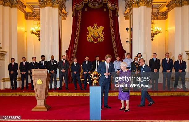 Prince Harry, Queen Elizabeth II and Prince Philip, Duke of Edinburgh view the Webb Ellis Trophy at a Rugby World Cup reception at Buckingham Palace...