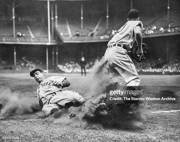 Joe DiMaggio of the New York Yankees is out at third on a force play as third baseman George Kell holds the ball in the secound inning on September...