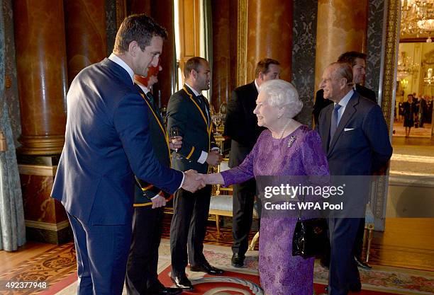 Queen Elizabeth II meets Wales' Rugby Union Captain Sam Warburton at a reception at Buckingham Palace to welcome Rugby World Cup stars on October 12,...