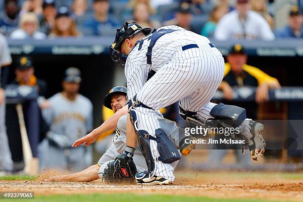 Gaby Sanchez of the Pittsburgh Pirates is tagged out by Brian McCann of the New York Yankees at Yankee Stadium on May 17, 2014 in the Bronx borough...
