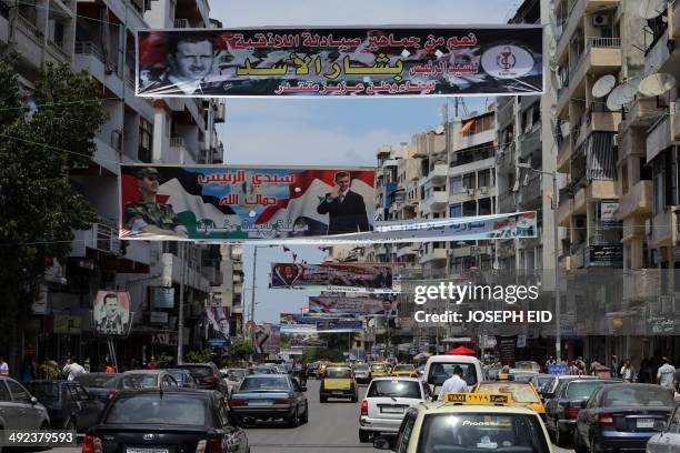 Election campaign posters bearing portraits of President Bashar al-Assad hang over a street in Syria's Mediterranean port city of Latakia on May 19,...