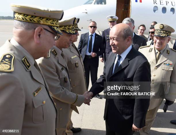 French Defence Minister Jean-Yves Le Le Drian followed by Algeria's Chief of Staff General Ahmed Gaid Salah is greeted upon his arrival at the...