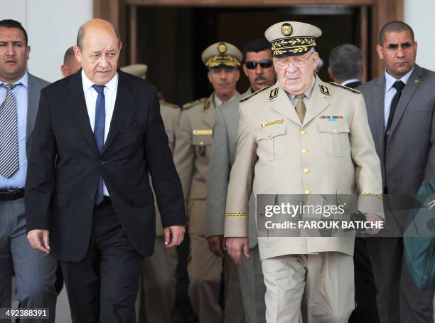 French Defence Minister Jean-Yves Le Le Drian walks with Algeria's Chief of Staff General Ahmed Gaid Salah upon his arrival at the Houari-Boumediene...