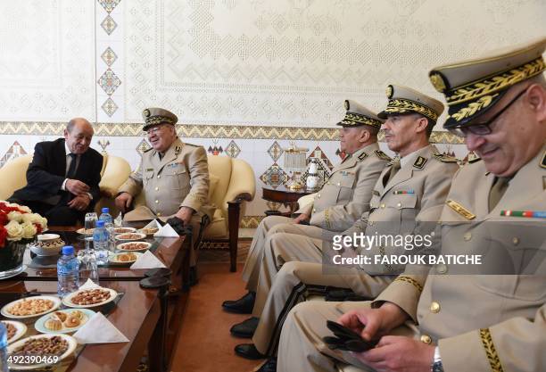 French Defence Minister Jean-Yves Le Le Drian speaks with Algeria's Chief of Staff General Ahmed Gaid Salah upon his arrival at the Houari-Boumediene...