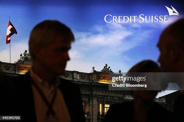 Attendees pass an advertisement for Credit Suisse Group AG during a break in sessions at the Swiss International Finance Forum in Bern, Switzerland,...