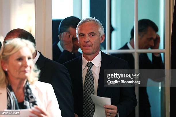Urs Rohner, chairman of Credit Suisse Group AG, center, holds a piece of paper as he arrives to attend the Swiss International Finance Forum in Bern,...