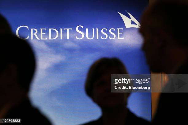 Attendees pass an advertisement for Credit Suisse Group AG during a break in sessions at the Swiss International Finance Forum in Bern, Switzerland,...