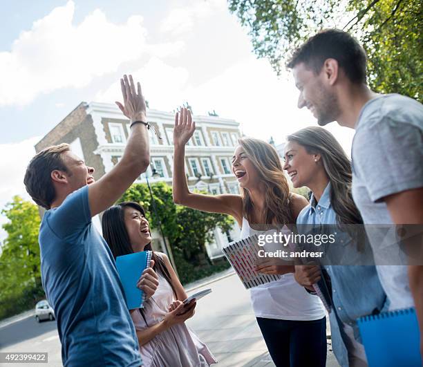 students giving a high-five - study abroad stock pictures, royalty-free photos & images