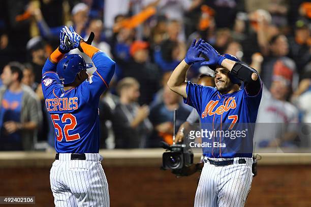 Travis d'Arnaud of the New York Mets celebrates with Yoenis Cespedes after hitting a two run home run in the third inning against Brett Anderson of...