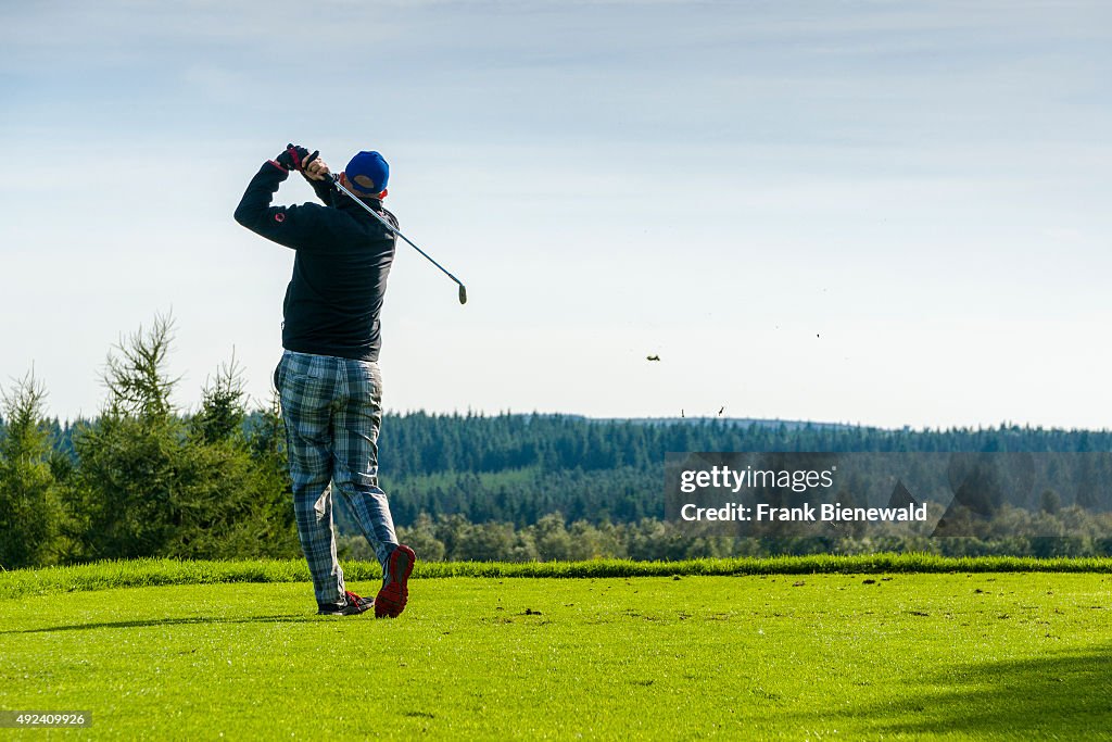 A man is playing golf on a golf course...