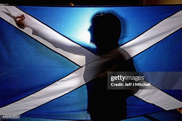 Members of staff at James Stevenson Flags hold a Union Jack and Saltire flag on May 20, 2014 in Glasgow, Scotland. A referendum on whether Scotland...