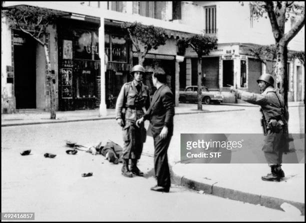 Deux soldats algériens de l'armée française discutent près du corps d'une victime de la fusillade de la rue d'Isly à Alger le 26 mars 1962 contre des...