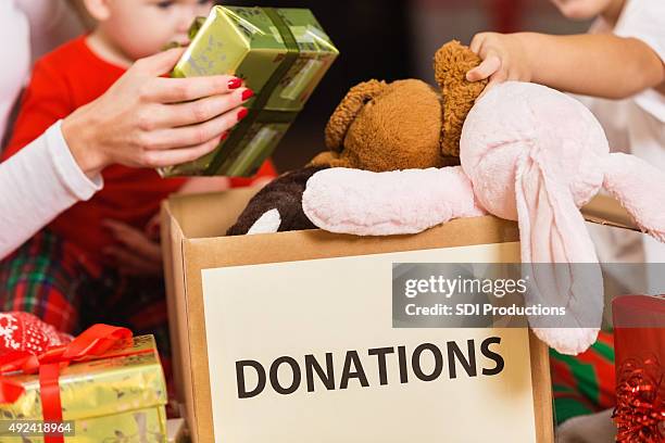 famiglia regali e giocattoli donazione per beneficenza per vacanze di natale - child giving gift foto e immagini stock