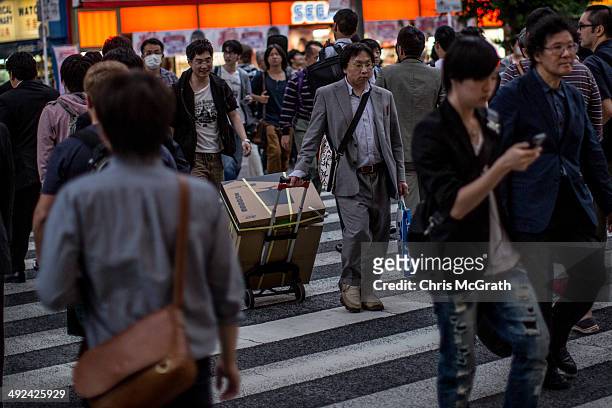 Man crosses the street carrying electronic goods in Akihabara, Electric Town on May 20, 2014 in Tokyo, Japan. Akihabara gained the nickname Akihabara...