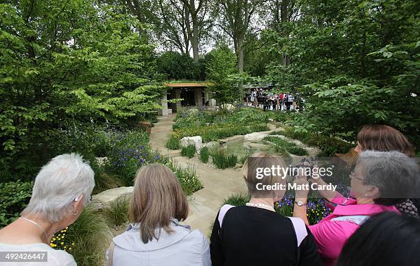 Visitors gather to admire the Homebase award winning garden at the RHS Chelsea Flower Show in the grounds of the Royal Hospital Chelsea on May 20,...