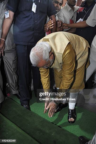 Prime minister-designate Narendra Modi bends down with folded hands on the steps of Parliament building as a sign of respect as he arrives for the...