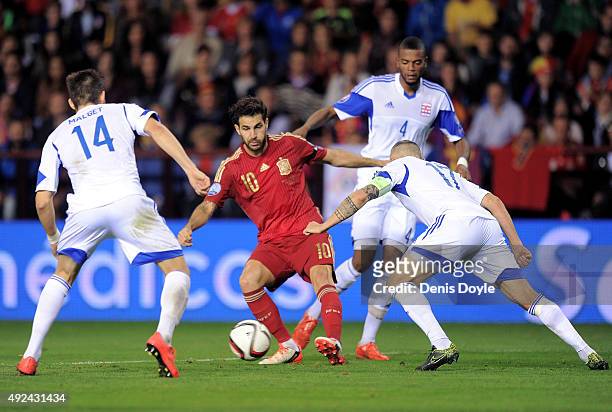 Cesc Fabregas of Spain tries to outsmart Kevin Malget and Mario Mutsch of Luxembourg during the UEFA EURO 2016 Qualifier group C match between Spain...