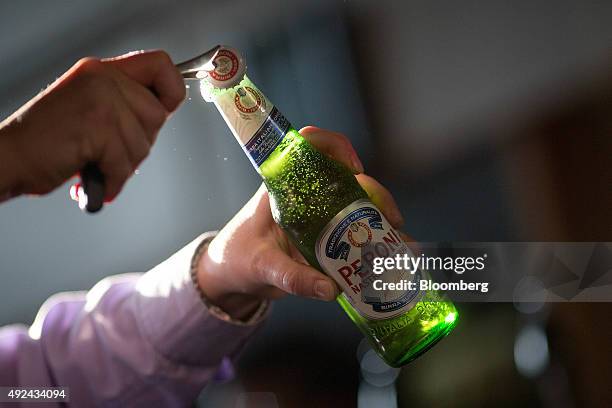 Barman opens a bottle of Peroni beer, brewed by SABMiller Plc, in The Capitol, a JD Wetherspoons Plc public house, in this arranged photograph in...