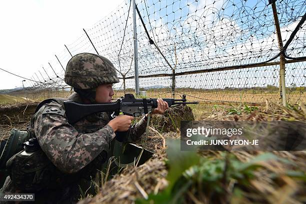 South Korean soldier stands guard in front of a military fence at a General Outpost of the Demilitarized Zone dividing the two Koreas in Cheorwon on...