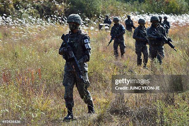 South Korea soldiers patrol during a demonstration of a search operation at a training field in Cheorwon near the Demilitarized Zone dividing the two...