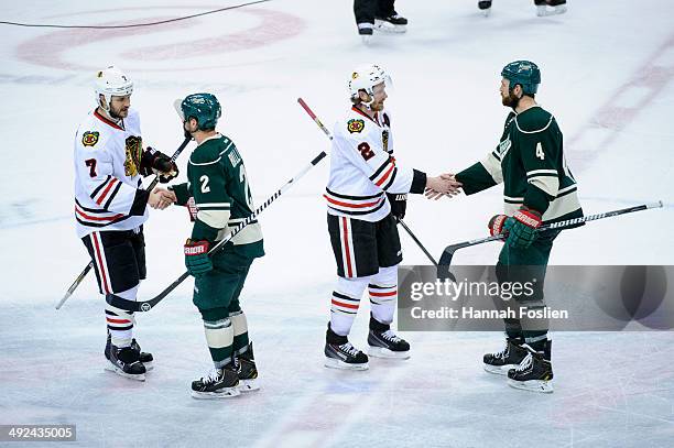 Brent Seabrook and Keith Ballard of the Chicago Blackhawks shake hands with Keith Ballard and Clayton Stoner of the Minnesota Wild after Game Six of...