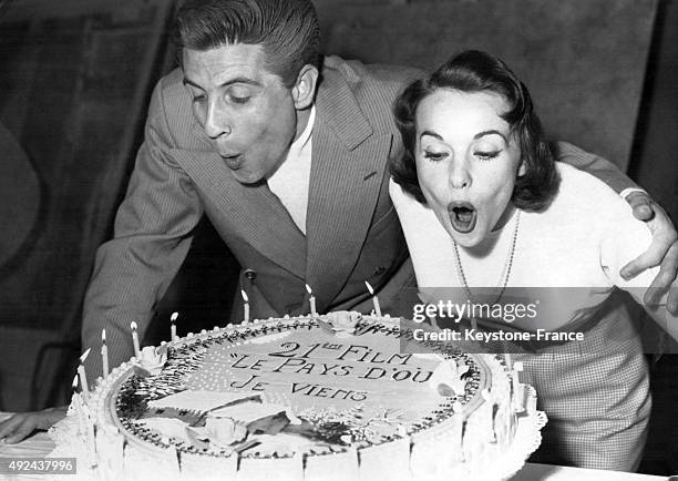 Gilbert Becaud and actress Frances Arnold, partners of the film 'Le Pays d'ou je viens' which is the 21st film of the actress, blow out the candles...