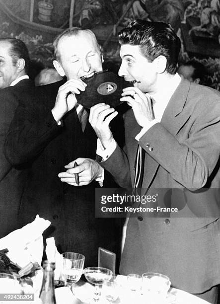 Bourvil and Gilbert Becaud munch a chocolate disc, Bourvil was awarded with the Prize of the City of Paris and the Gilbert Becaud was awarded with...