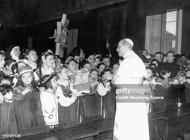 Un groupe d'enfants de differentes nationalites rencontrent le Pape Pie XII le 12 janvier ,1958 a Rome, Italie.