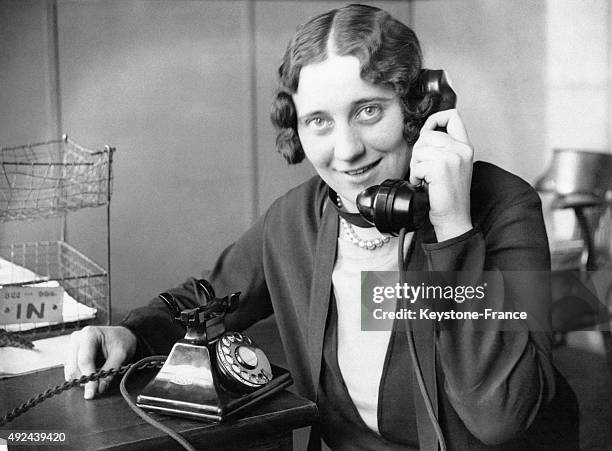 Une femme utilise un 'neophone', appareil combinant a la fois le cadran et le combine telephonique en un seul et meme boitier.