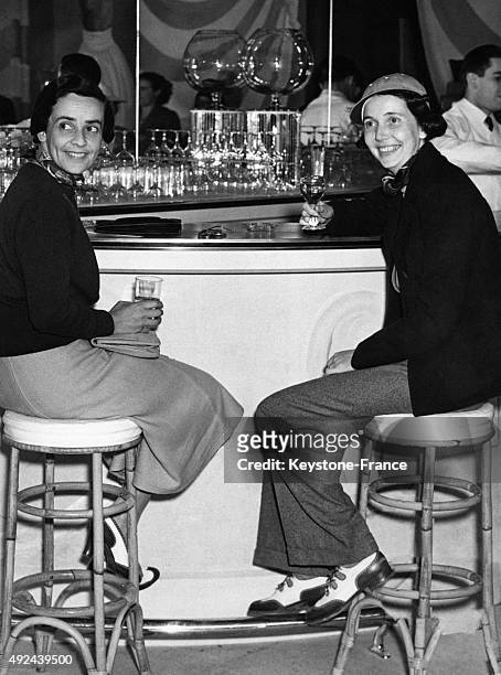 Mrs John Barry Ryan et la Baronne Guy de Rothschild au comptoir de 'L'alibi', un nouveau bar ouvert sous l'egide d'Alastair Mackintosck d'Angleterre...