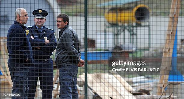 Bosnian policeman speaks with mine at the entrance to the "Begici" coal mine near the Central-Bosnian city of Kakanj on October 13 after mining...