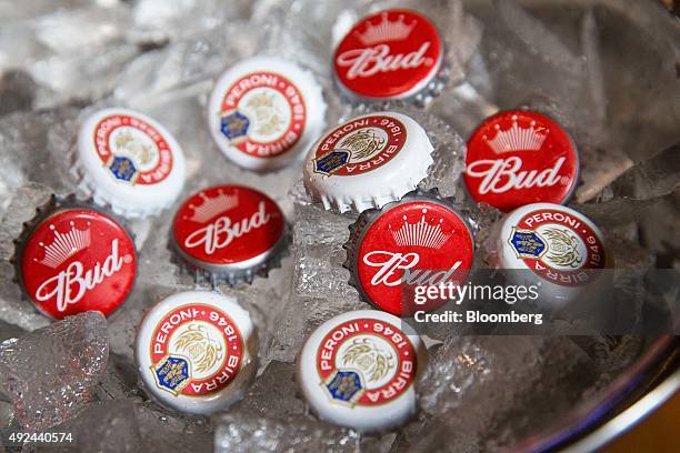 Bottle caps from Peroni beer, brewed by SABMiller Plc, and Budweiser beer, brewed by Anheuser-Busch InBev NV, sit in a bucket of ice in The Capitol,...